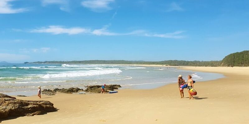 South Valla Beach, people walking on the sand alongside the waves